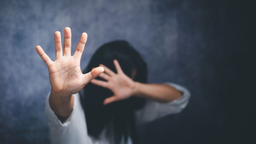 Woman With Hands Raised In A Defensive Gesture