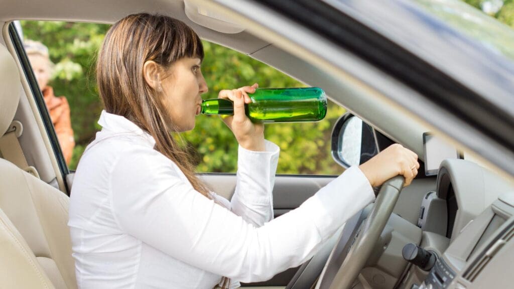 Woman Drinking from a While Driving